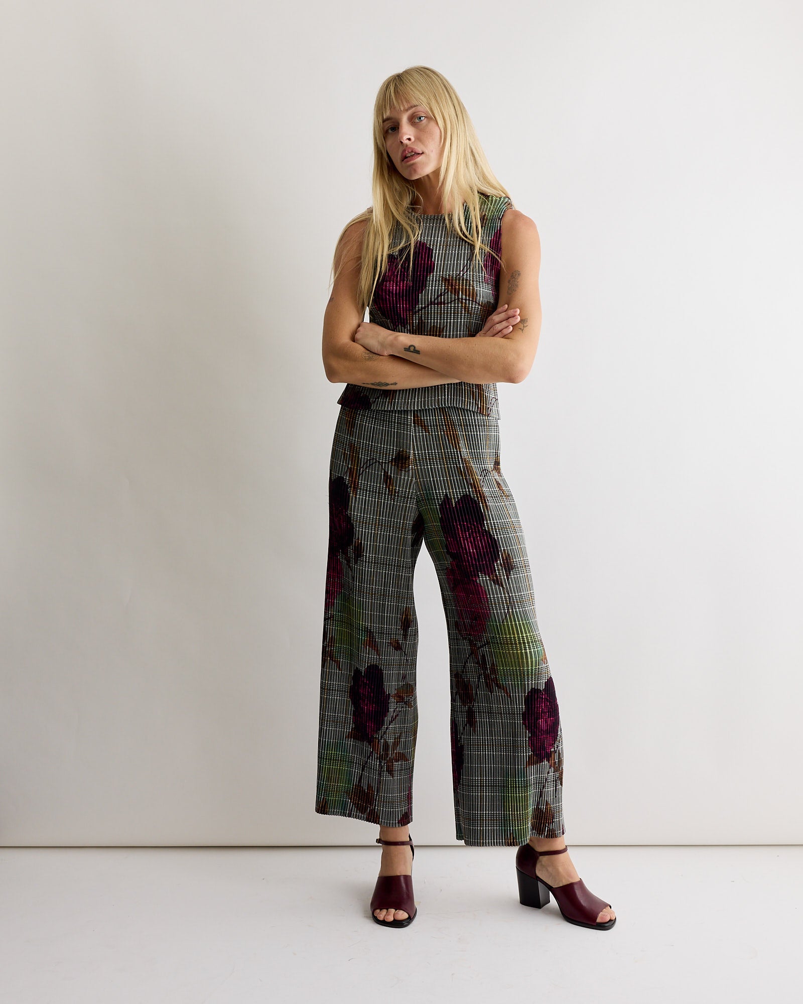 A woman stands with her arms crossed, wearing Julia Heuer's Jack Trouser in Rosalind, crafted from recycled polyester crepe.