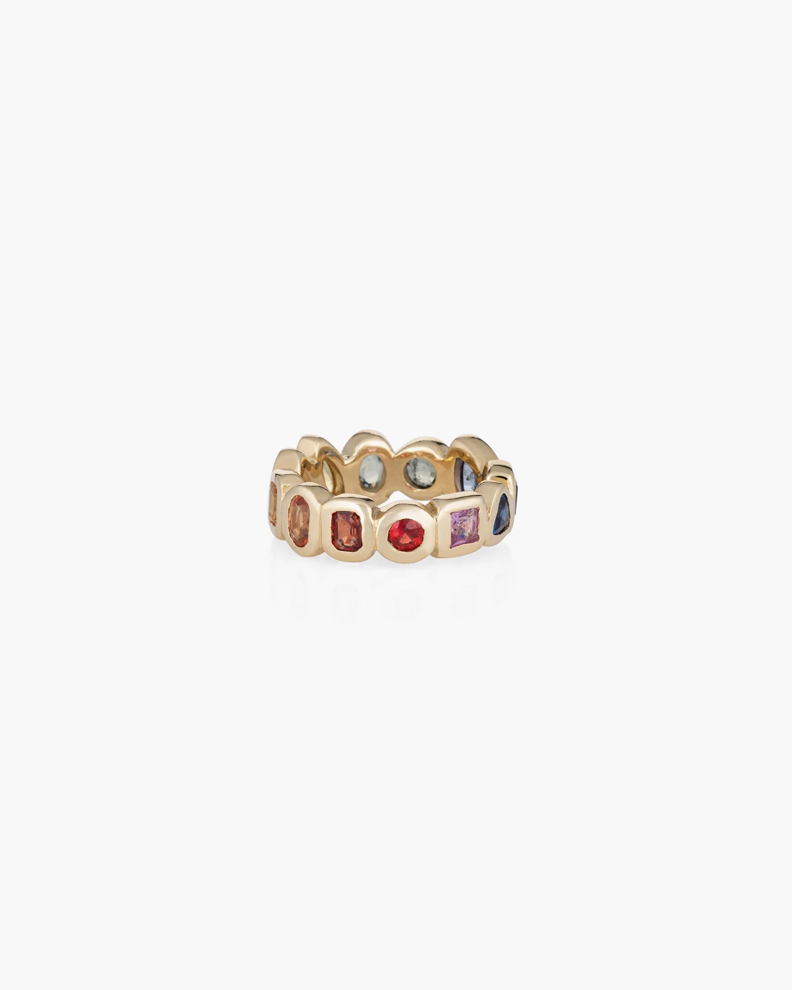 The Kathryn Bentley Confetti Band is a handmade 14K gold ring set with an alternating pattern of multi-colored sapphires in various shapes, shown against a plain white background.