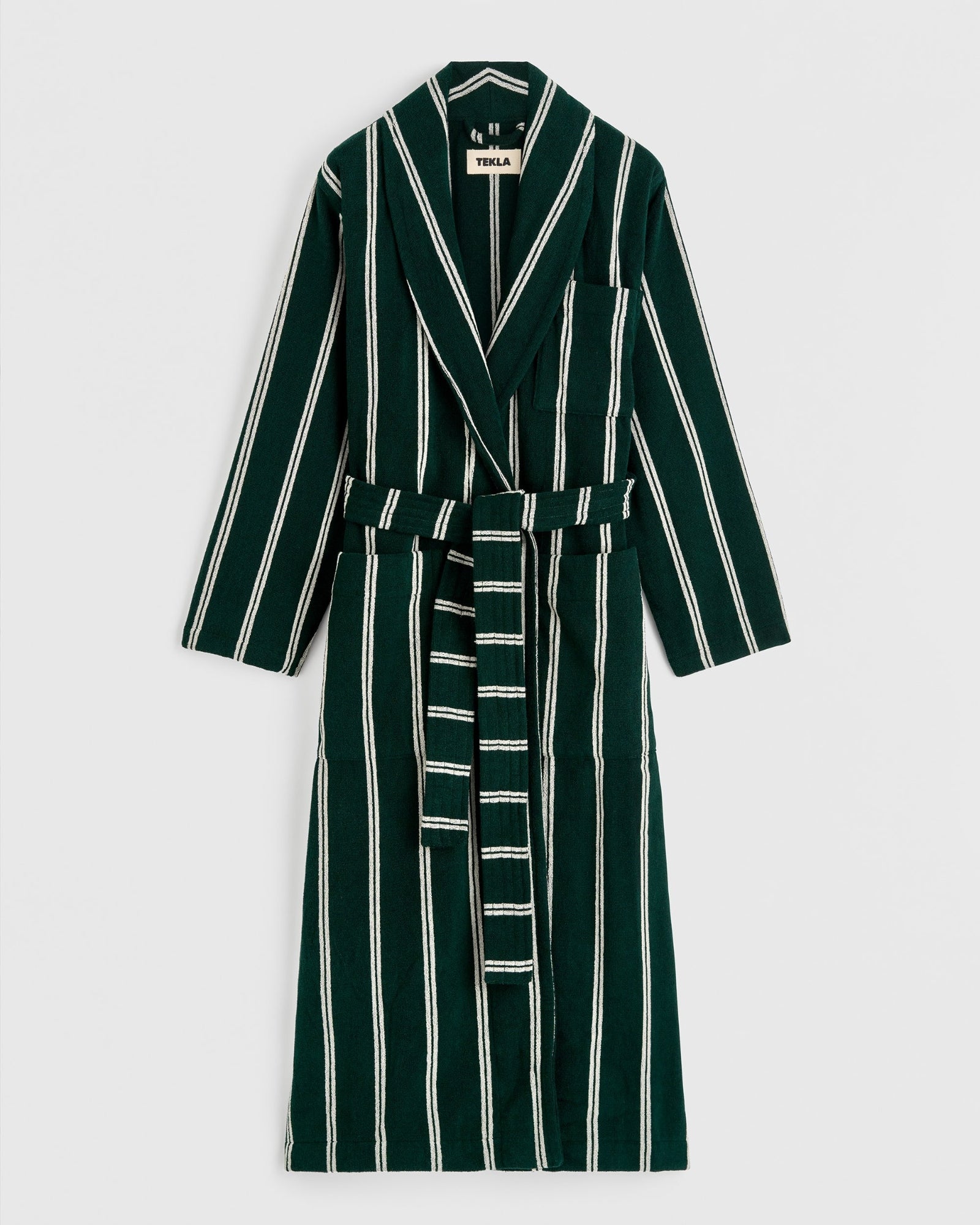 The Classic Bathrobe in Forest Green Stripes by TEKLA features white vertical stripes, a notched collar, long sleeves, front pocket, and matching belt. Made in Portugal from eco-friendly organic cotton and shown on a plain white background.