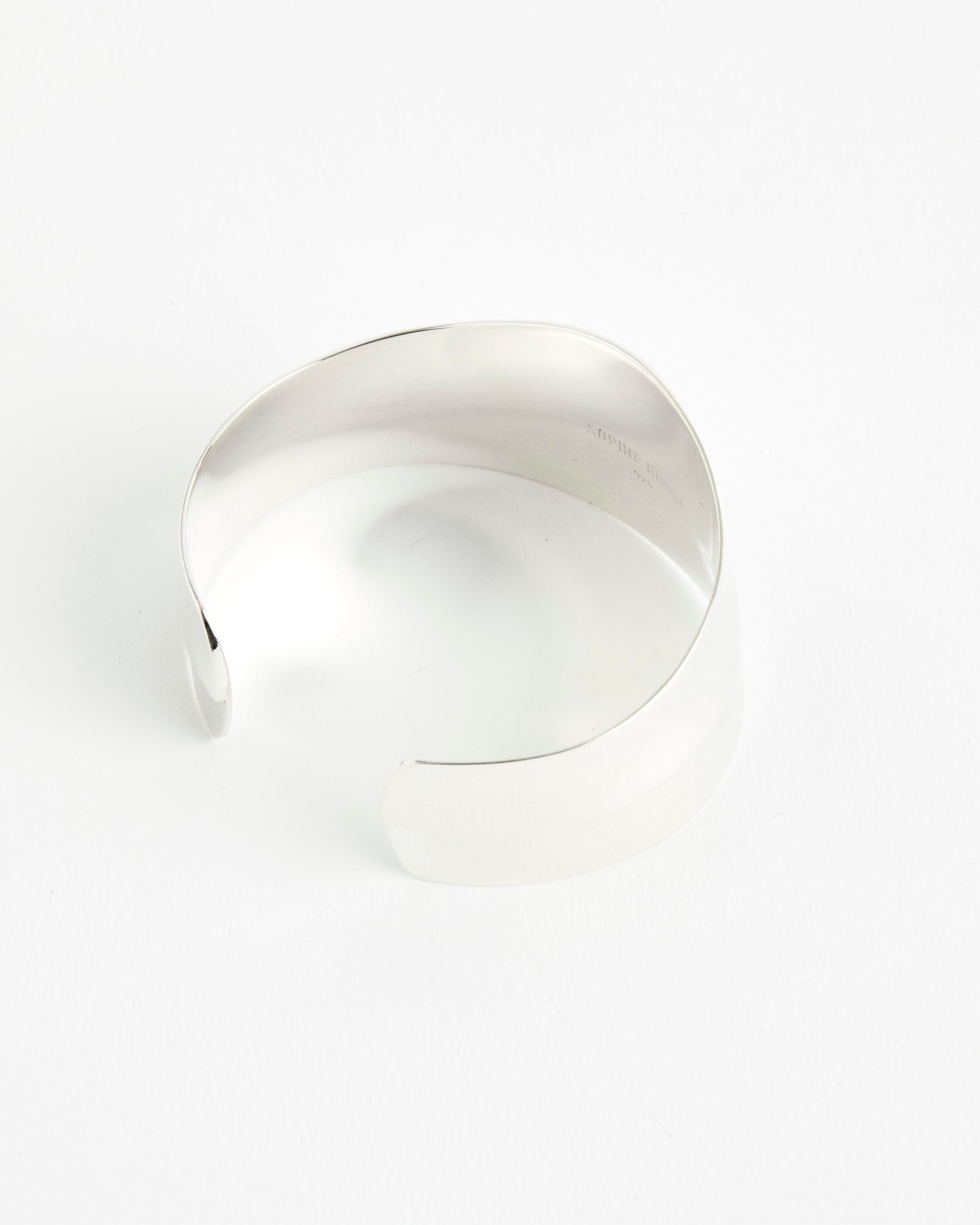 The Sophie Buhai Petite Wave Cuff, a silver open bracelet with a smooth, polished finish and minimalist design, is shown on a white background. For fit or sizing help, connect with our online chat for personalized assistance.