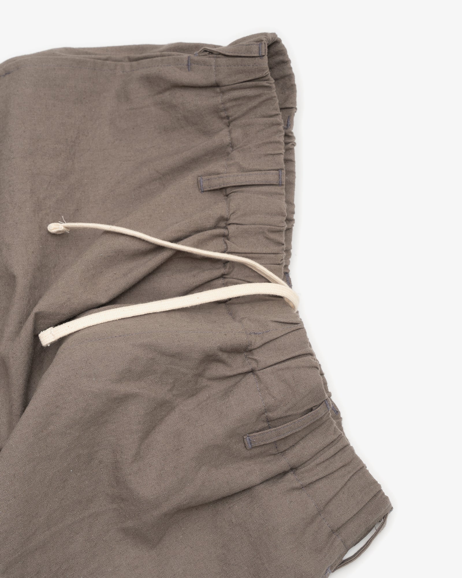 Close-up of the James Coward Carry On Pant in Mid Grey, featuring an elastic waistband and off-white drawstring, shown on a white background.
