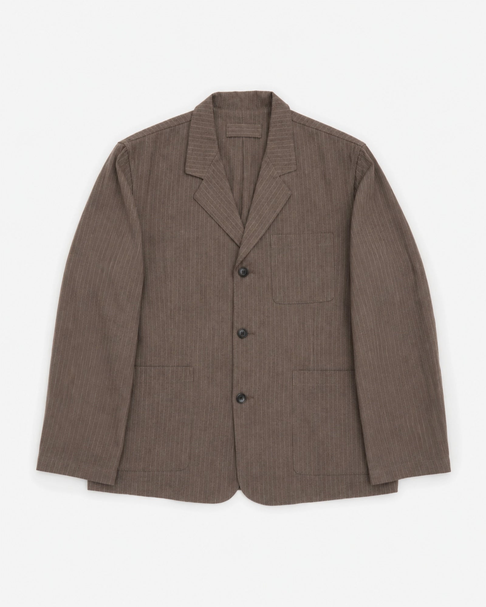 The James Coward Carry On Jacket in Dark Brown features a notched collar, three front buttons, and three pockets. Crafted from Japanese twill, it is shown flat on a white background.