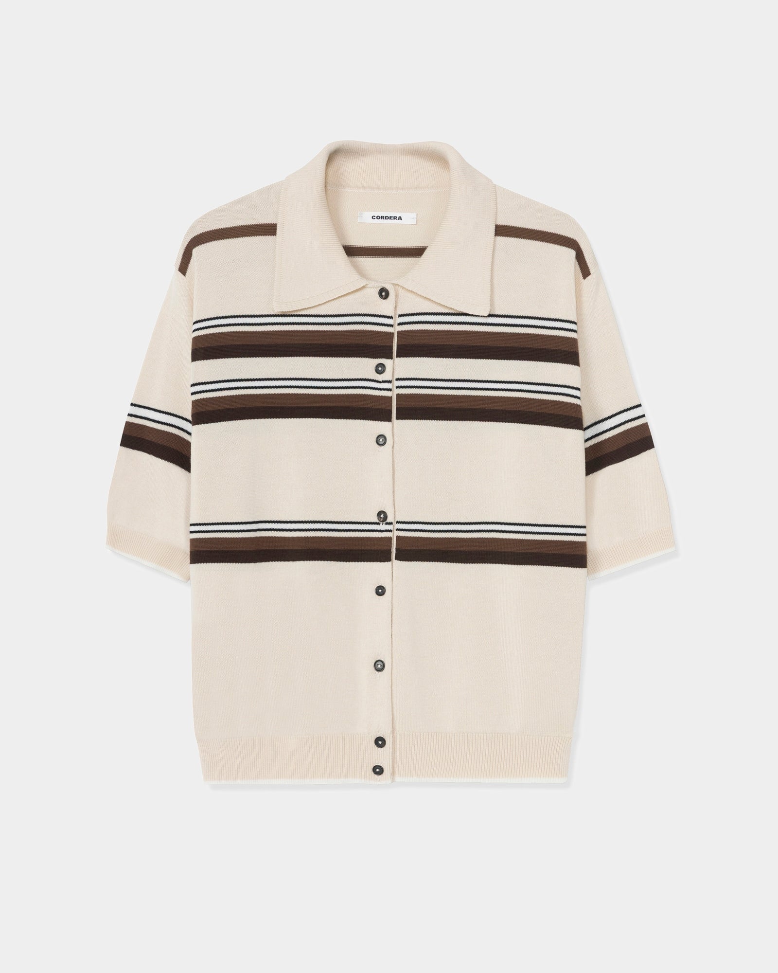 The CORDERA Striped Polo in Multi features a beige short-sleeve knit design with brown and white stripes, a button-down front, ribbed hem, wide collar, and an oversized fit, shown against a plain white background.