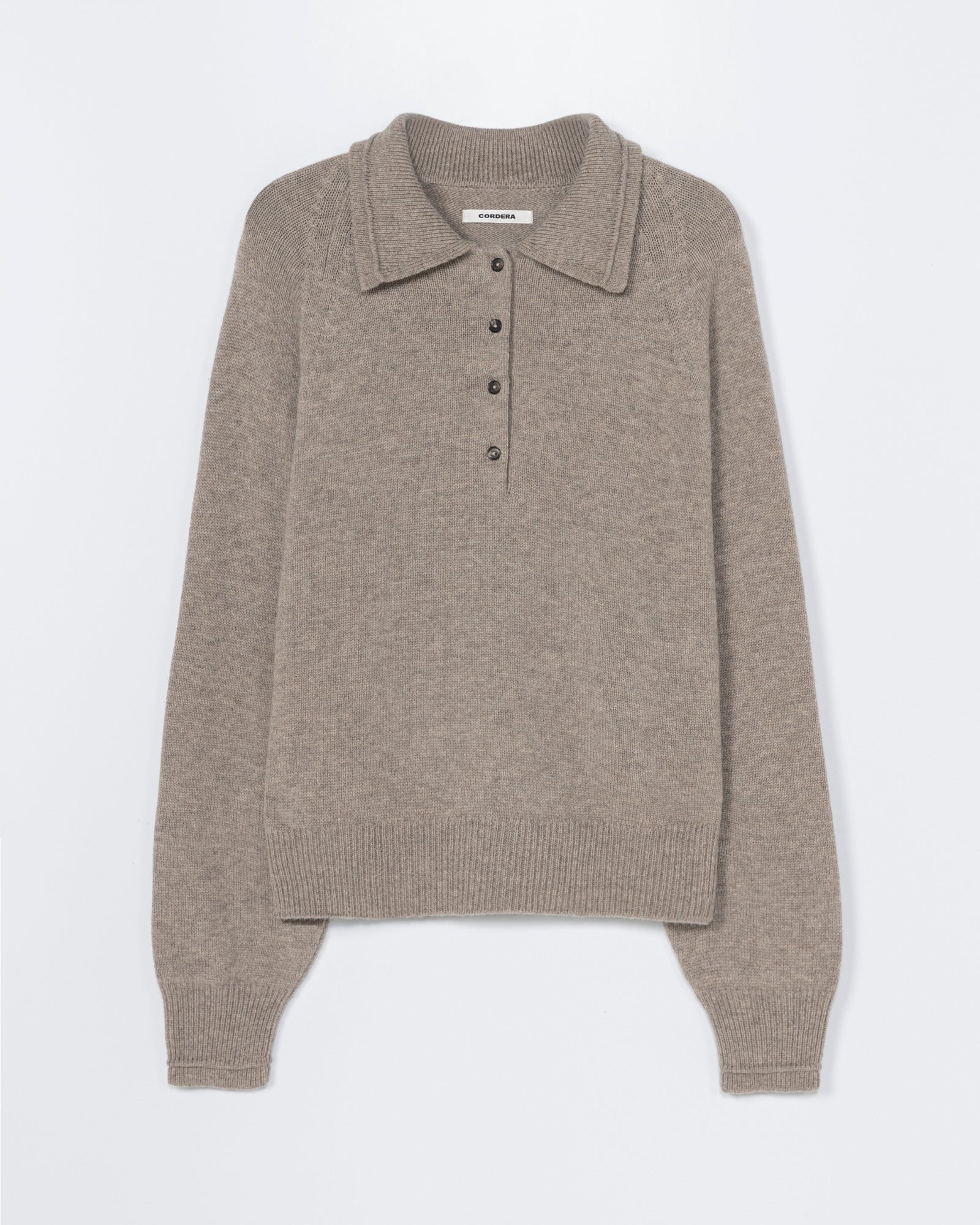The CORDERA Merino Wool Polo Sweater in Taupe features long sleeves, a collar, and four front buttons, shown against a white background. For sizing and fit details, please contact our online chat support.