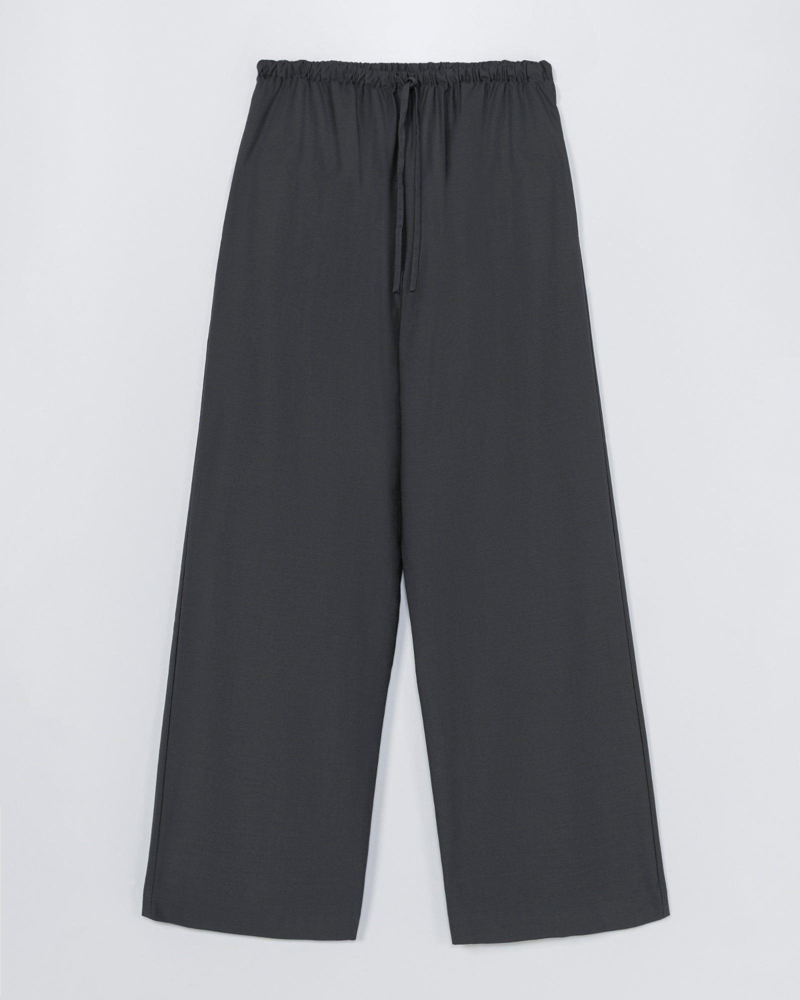 The CORDERA Tailored Drawstring Pant in Ebony offers a loose, wide-leg fit with an elastic waistband and drawstring—ideal for comfort and a relaxed look. For sizing questions, our online chat is here to help.