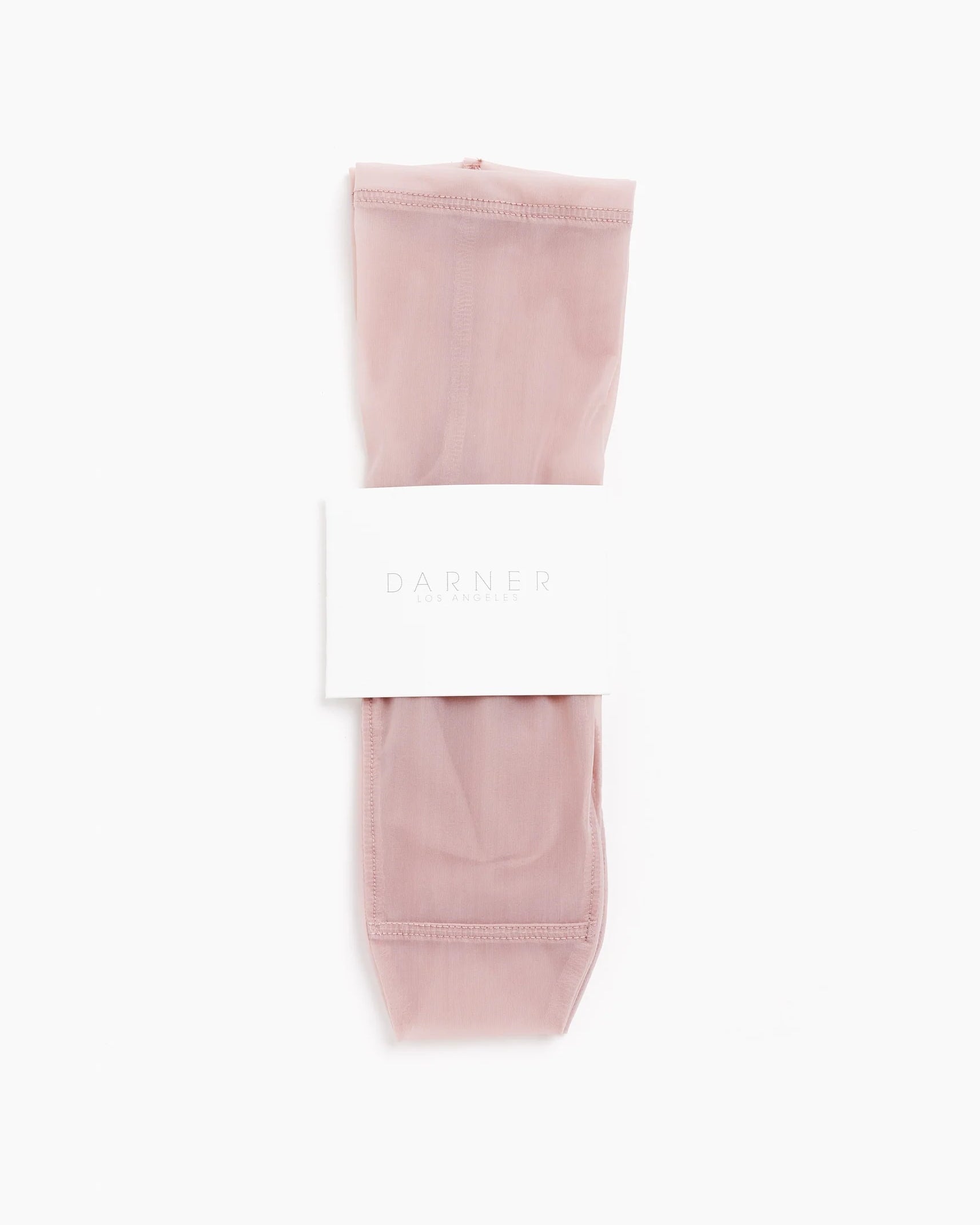 A pair of Darner Solid Mesh Socks in Blush, featuring a sheer finish, are neatly folded with a white label showing the brand name and displayed against a plain white background.