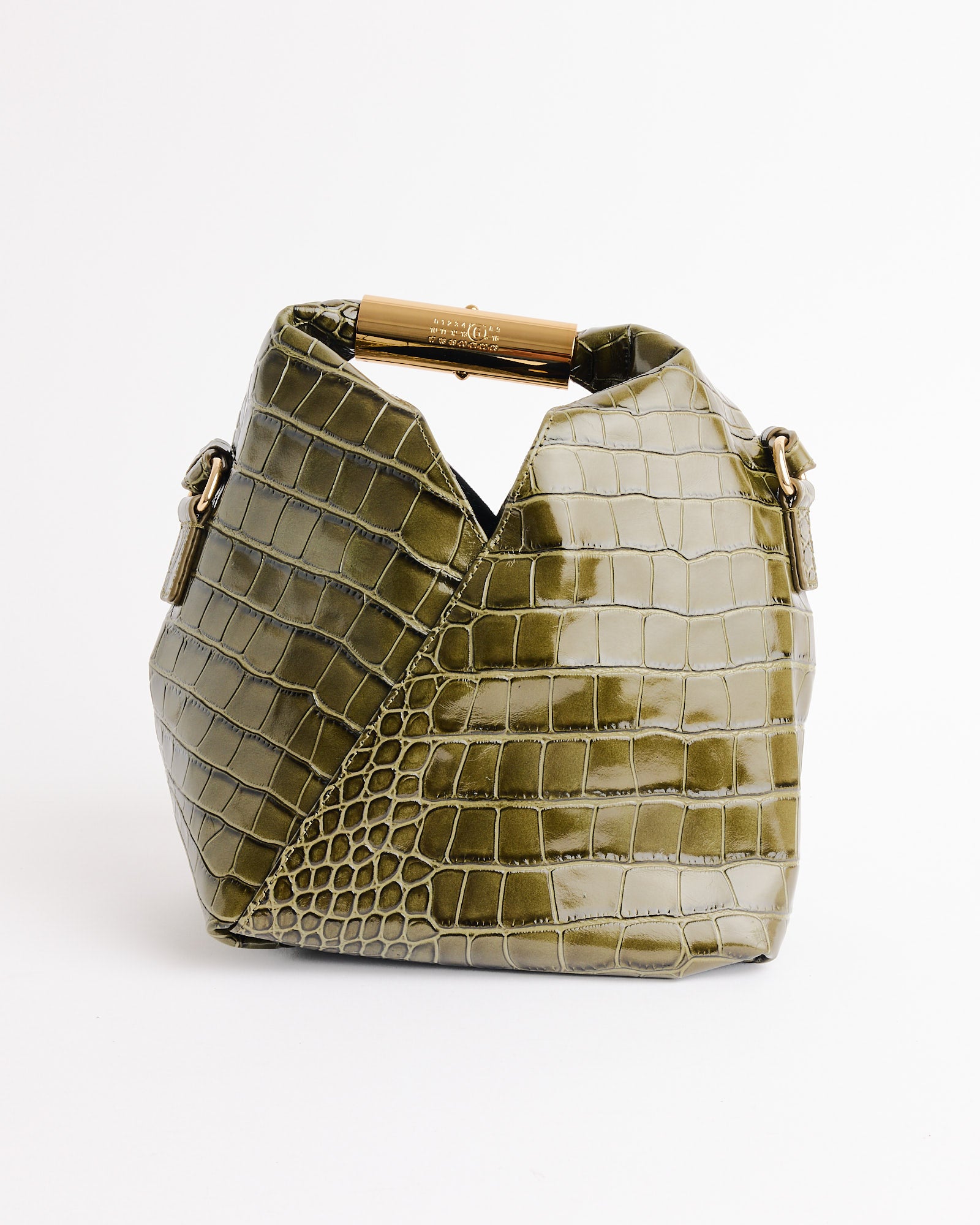 The Japanese Small Bag in Olive by MM6 Maison Margiela features a crocodile-print leather, gold hardware, and a unique folded design, all presented against a plain white background.