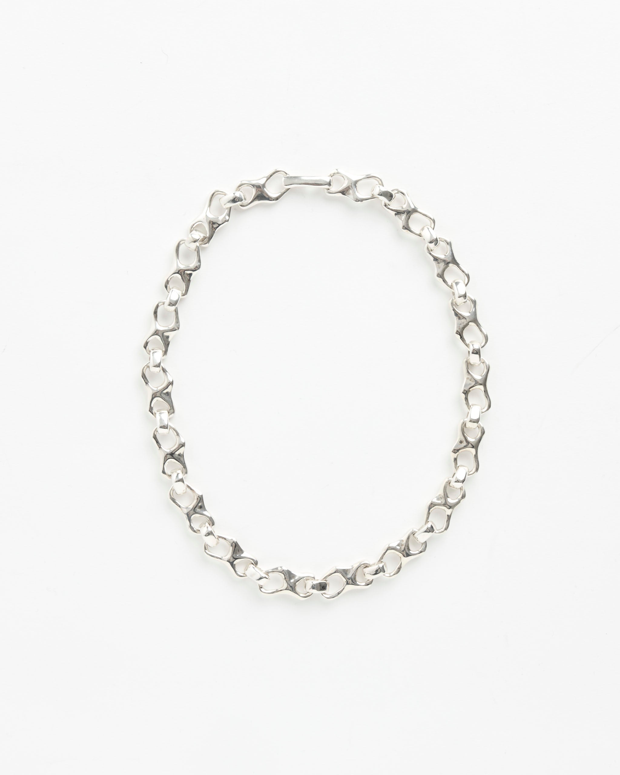 The Faris Tab Collar is a silver chain necklace with oval and rounded rectangular links, shown in a loop on a white background—perfect for any fit. Have sizing questions? Connect with us through online chat.