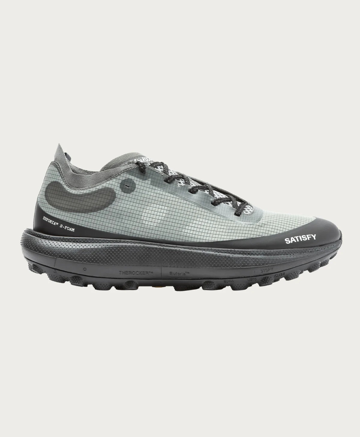 The Rocker in Shadow by Satisfy Running is a modern trail shoe with a gray grid-patterned upper, black laces, thick black cushioned sole, and SATISFY branding with small text on the side and sole.