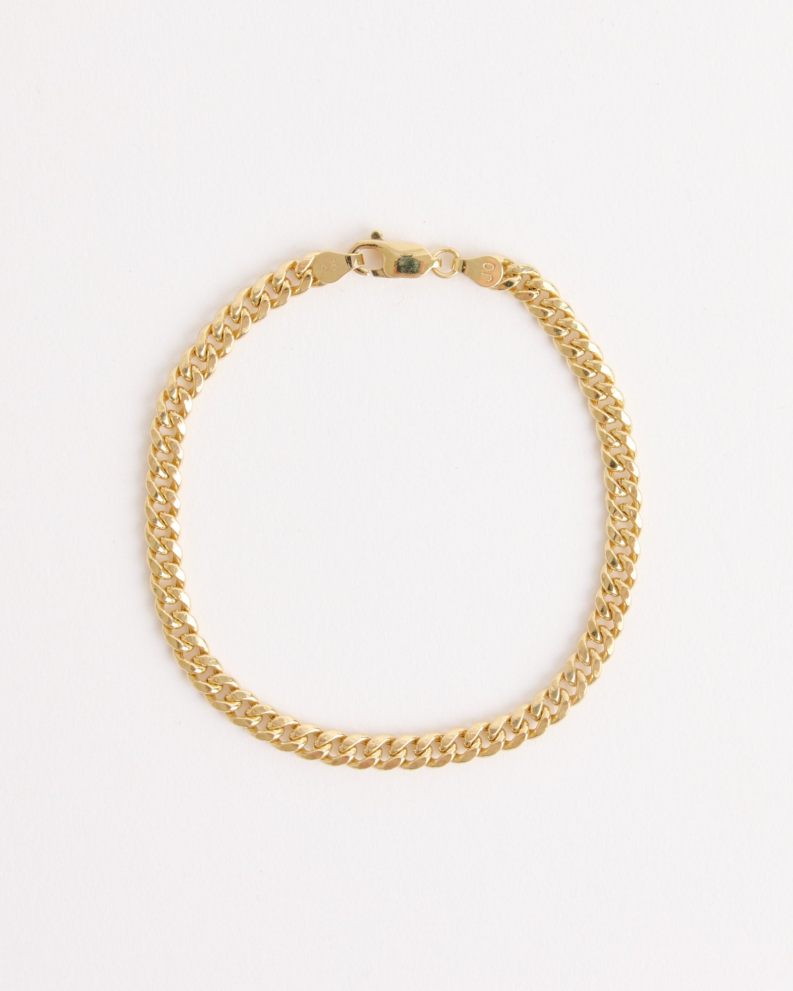 The SHOPDELAGOLD Chunky Miami Cuban Bracelet in 14K yellow gold features a bold curb link design, shown arranged in a circle on a plain white background.
