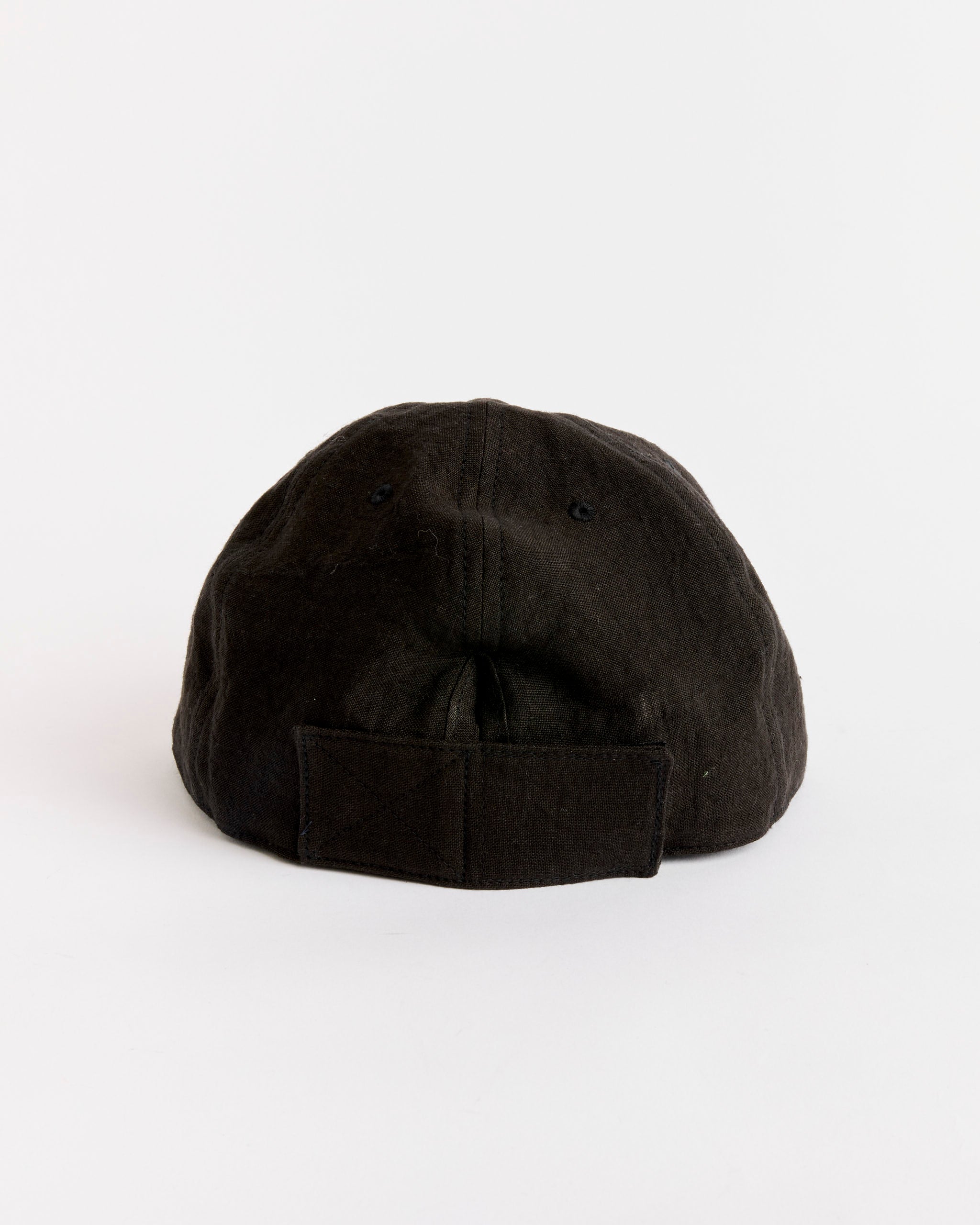 The SMOCK Velcro Back Cap in Sun Dried Linen Black is shown from the back, highlighting its fabric strap with a hook-and-loop fastener against a plain white background.