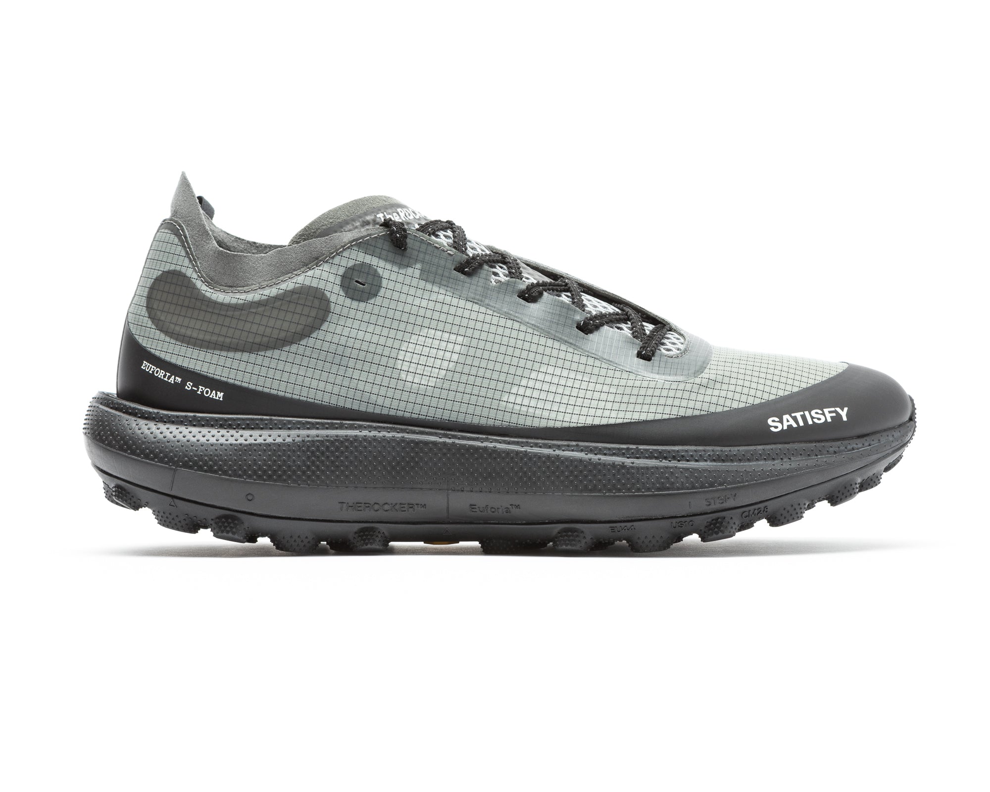 The Rocker in Shadow by Satisfy Running is a gray and black athletic trail shoe with a grid pattern, black laces, a thick Vibram Megagrip outsole, and “SATISFY” plus technical labels printed on the side and sole for extra style.